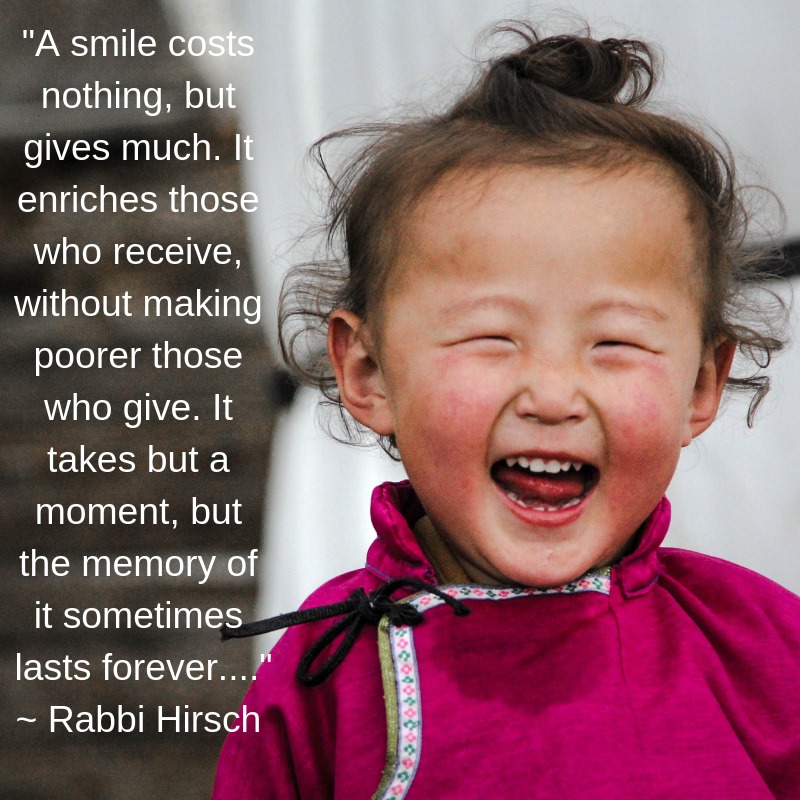 A picture of a laughing child with brown hair and a pink outfit. Text on the left reads:
"A smile costs nothing, but it gives much. It enriches those who recieve, whithout making poorer those who give. It takes but a moment, but the memory of it sometimes lasts forever..."
- Rabbi Hirsch